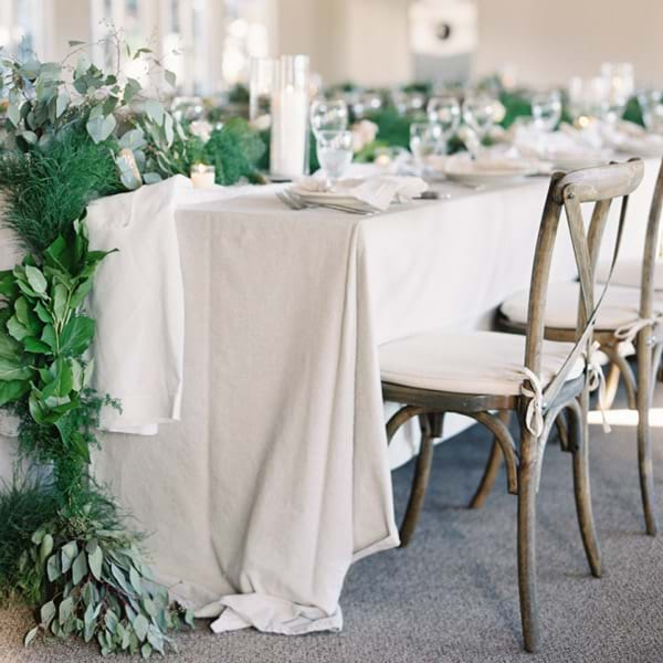 Rustic wood cross back chairs in a wedding setting